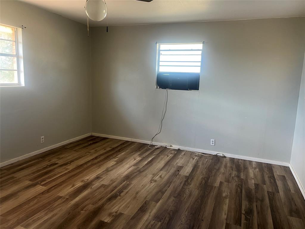 203 Washington Avenue Strawn, TX 76475 - Photo 15 of 20 Unfurnished room featuring dark wood-style floors and ceiling fan