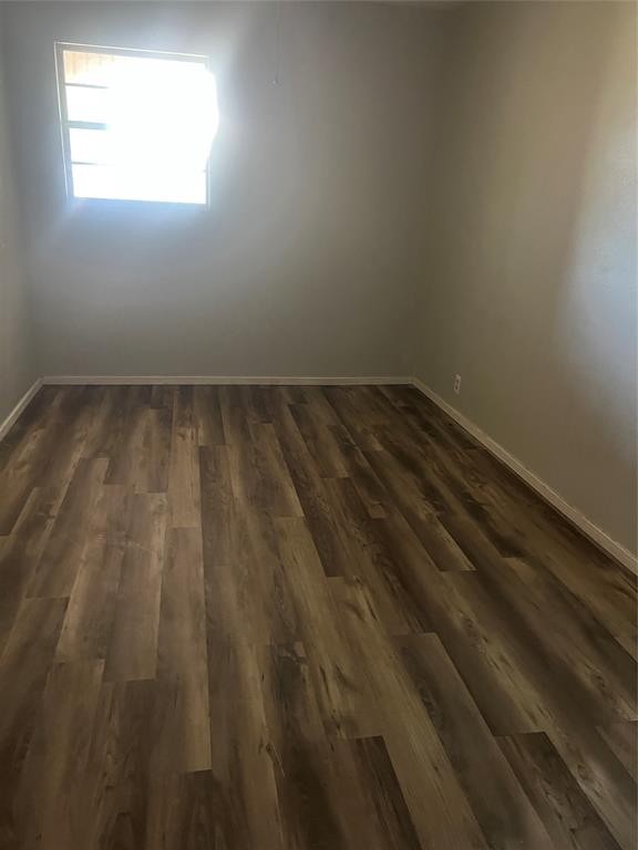 203 Washington Avenue Strawn, TX 76475 - Photo 10 of 20 Empty room with dark wood finished floors