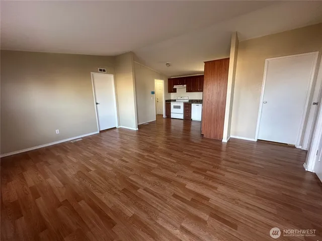a view of empty room with wooden floor