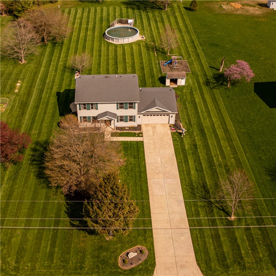 3628 Petre Road Springfield, OH 45502 - Photo 3 of 52 An aerial view captures a serene home with a wide green yard, long driveway, and a backyard pool.