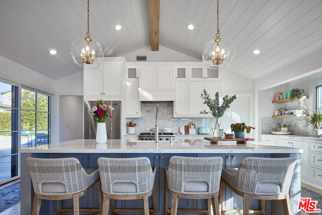 8388 Chase Avenue Los Angeles, CA 90045 - Photo 3 of 30 a kitchen with granite countertop a table chairs stove and cabinets