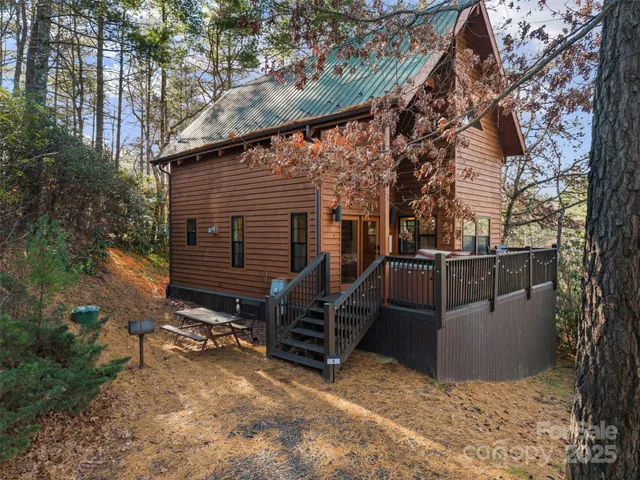 a backyard of a house with large trees and wooden fence