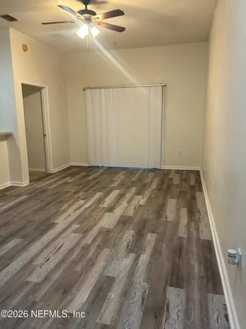 a view of a room with wooden floor and flat screen tv