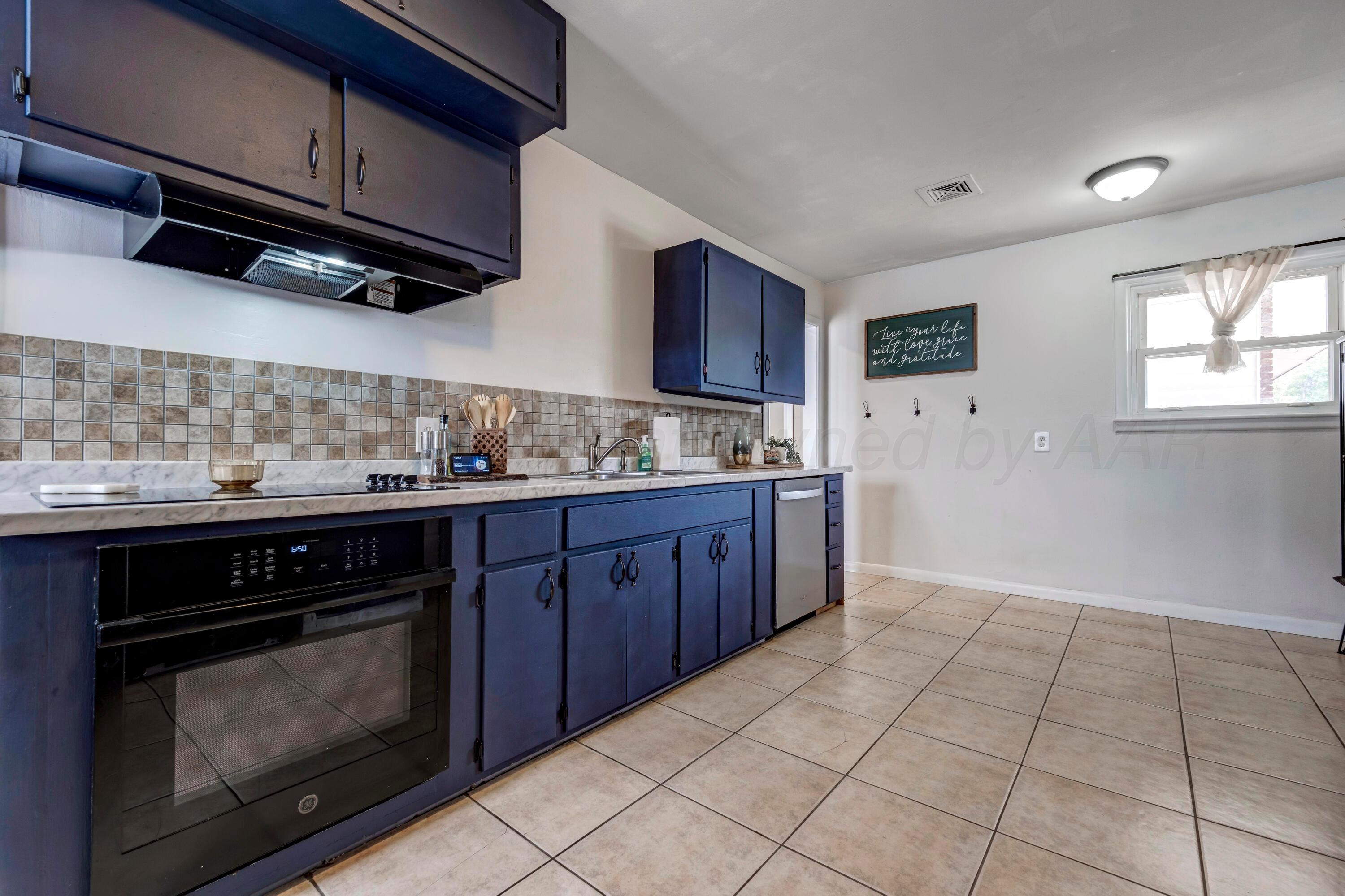 212 Teague Street Borger, TX 79007 - Photo 10 of 30 a kitchen with stainless steel appliances granite countertop a stove and a microwave