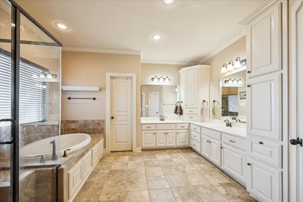 a spacious bathroom with a granite countertop tub sink a mirror a shower and vanity