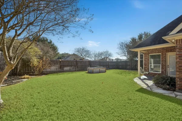 a backyard of a house with table and chairs