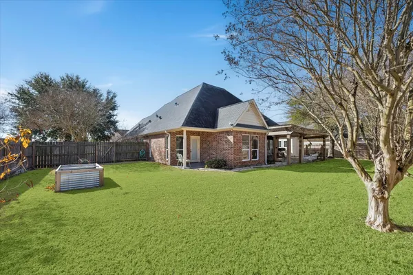 a front view of a house with a garden and trees