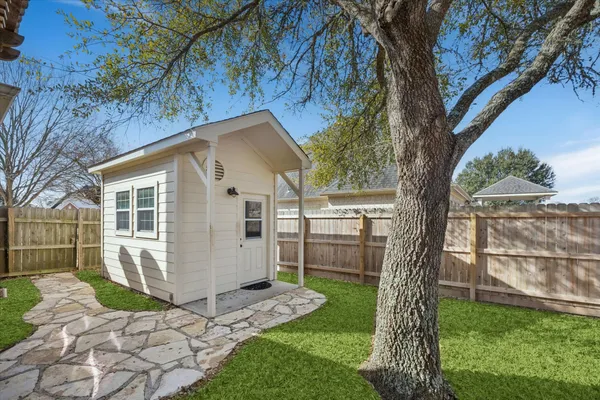a view of a small house with a tree in the backyard
