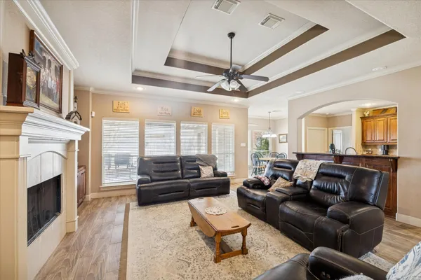 a living room with furniture a fireplace and a ceiling fan