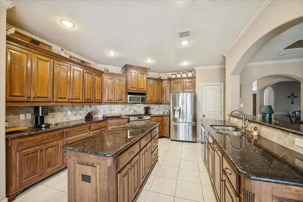 a kitchen with a sink stove top oven and refrigerator