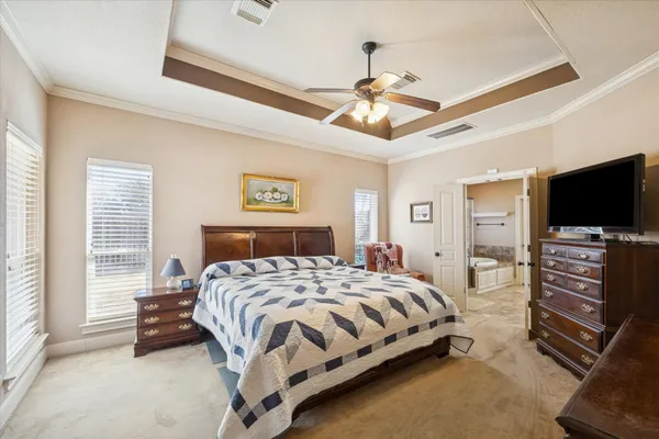 a bedroom with a bed and a flat tv screen on dresser