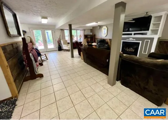 a living room with stainless steel appliances furniture a flat screen tv and a view of kitchen