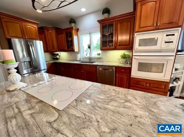 a kitchen with stainless steel appliances granite countertop a refrigerator a stove a sink and dishwasher