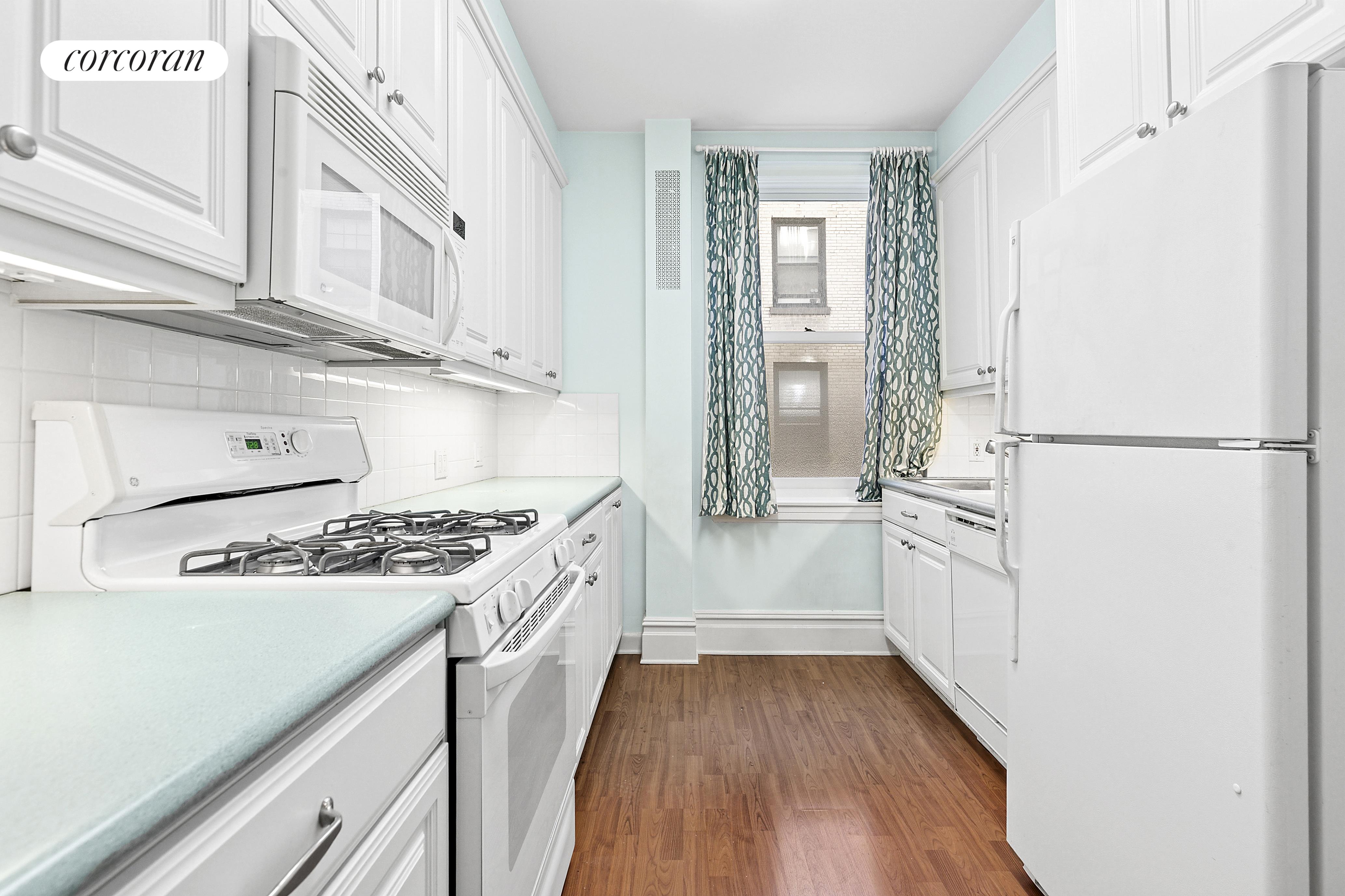 17 East 89th Street, Unit 8E Manhattan, NY 10128 - Photo 3 of 9 a kitchen with cabinets and a stove