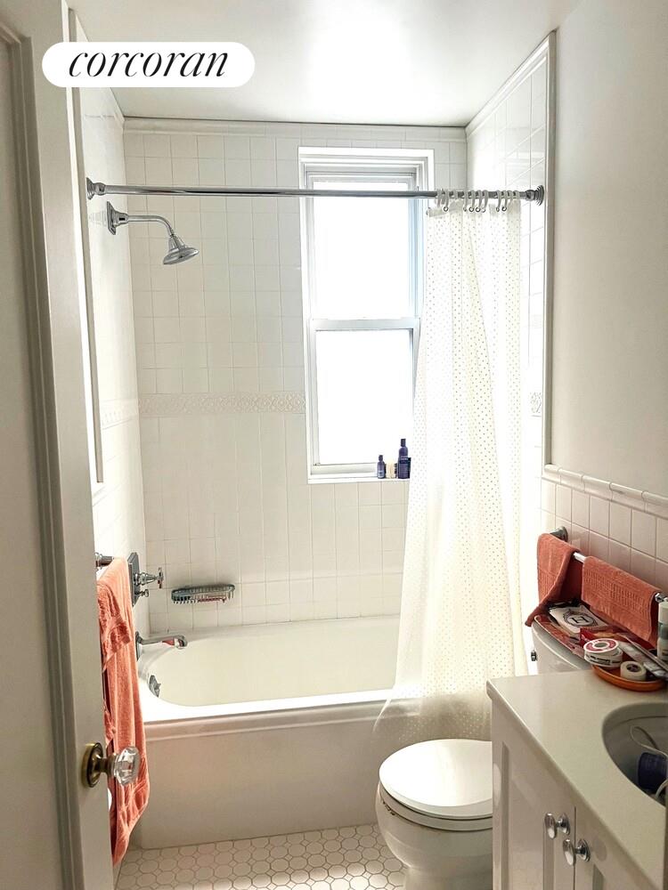 17 East 89th Street, Unit 8E Manhattan, NY 10128 - Photo 8 of 9 a bathroom with a granite countertop bathtub shower sink vanity and toilet