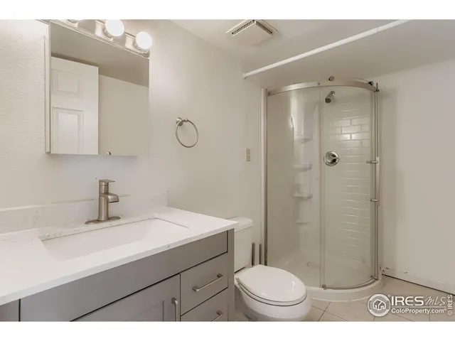 a bathroom with a sink a toilet a mirror and shower