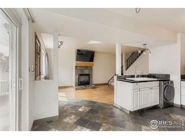 a living room with stainless steel appliances granite countertop furniture and a fireplace