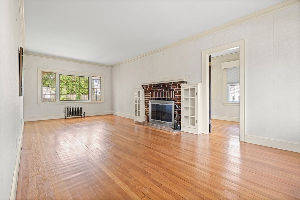 61 Waldeck Road Milton, MA 02186 - Photo 12 of 31 an empty room with windows fireplace and windows