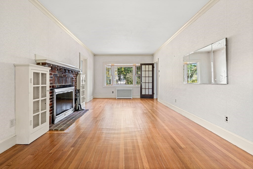 61 Waldeck Road Milton, MA 02186 - Photo 14 of 31 wooden floor fireplace and windows in an empty room