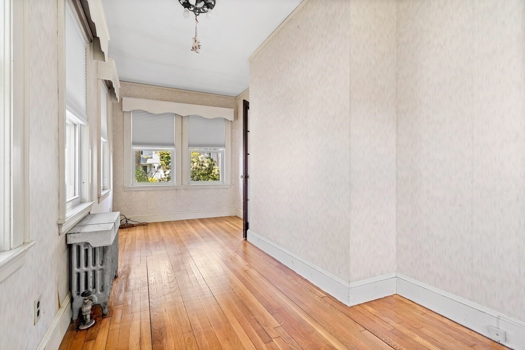 61 Waldeck Road Milton, MA 02186 - Photo 16 of 31 a view of an empty room with a window and wooden floor