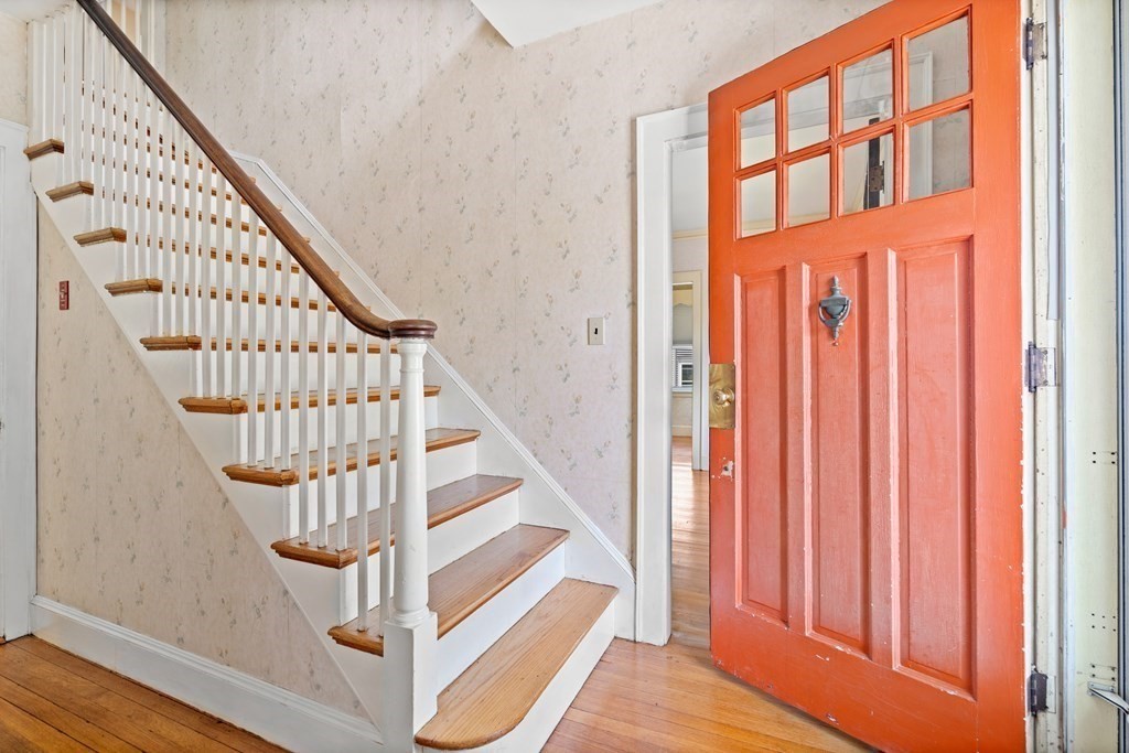 61 Waldeck Road Milton, MA 02186 - Photo 3 of 31 a view of staircase with lots of frames on wall and a window