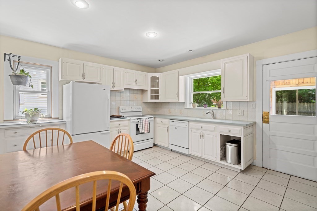 61 Waldeck Road Milton, MA 02186 - Photo 5 of 31 a kitchen with stainless steel appliances granite countertop a stove a sink a refrigerator dining table and chairs