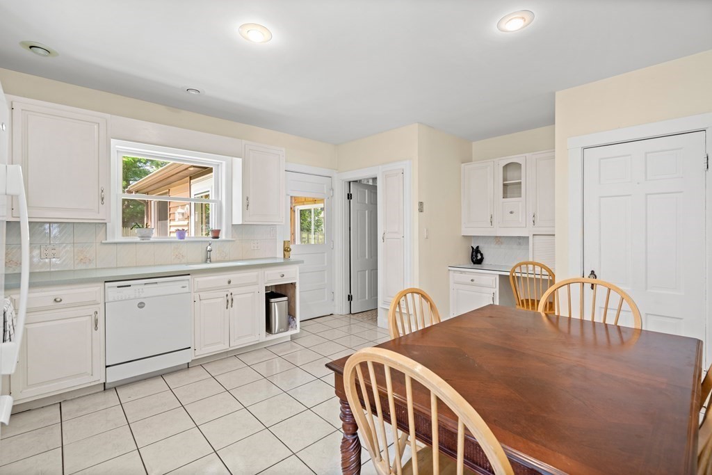 61 Waldeck Road Milton, MA 02186 - Photo 6 of 31 a kitchen with stainless steel appliances granite countertop a sink a stove a dining table and chairs