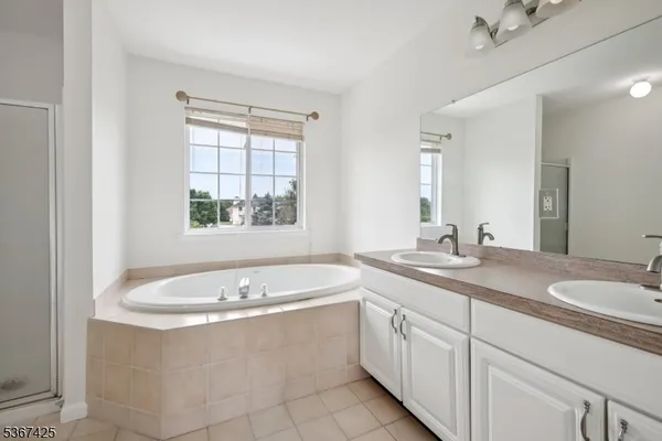a bathroom with a granite countertop bathtub sink and mirror