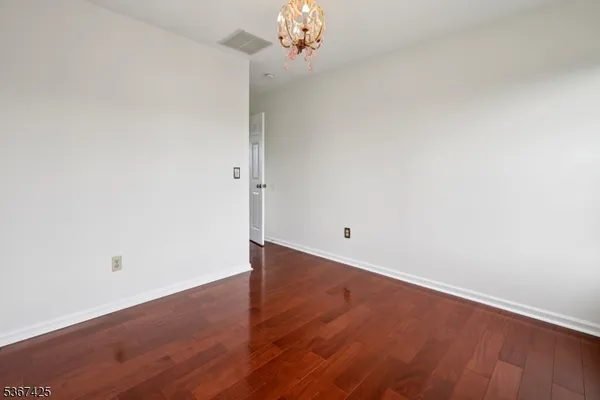 a view of a room with wooden floor and chandelier