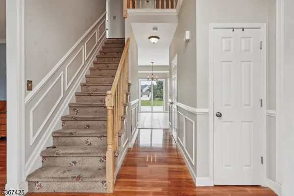 a view of a hallway with wooden floor and entryway