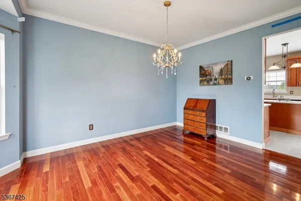 a view of empty room with wooden floor and window