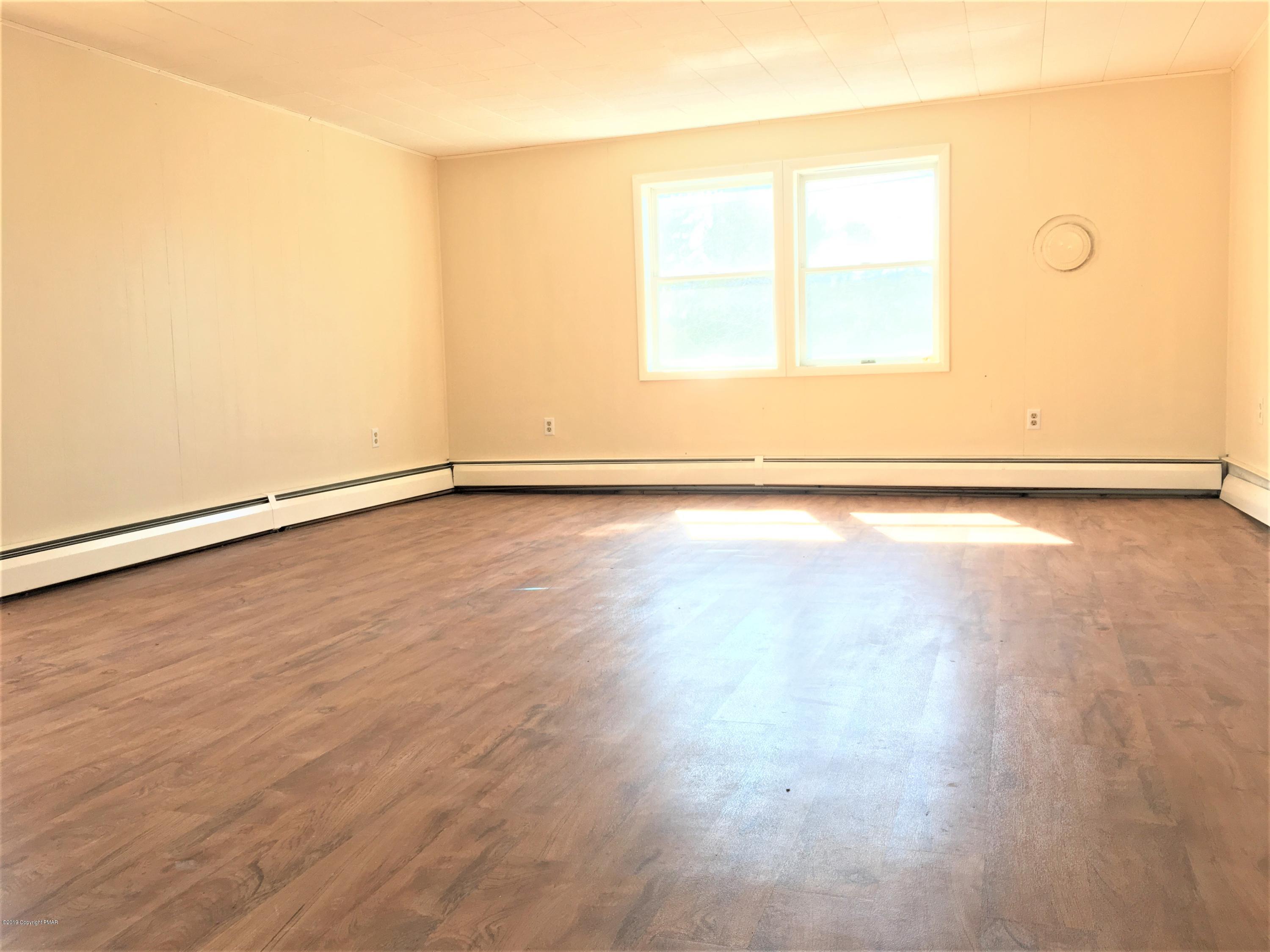 5736 Neola Road Stroudsburg, PA 18360 - Photo 13 of 37 an empty room with wooden floor and windows