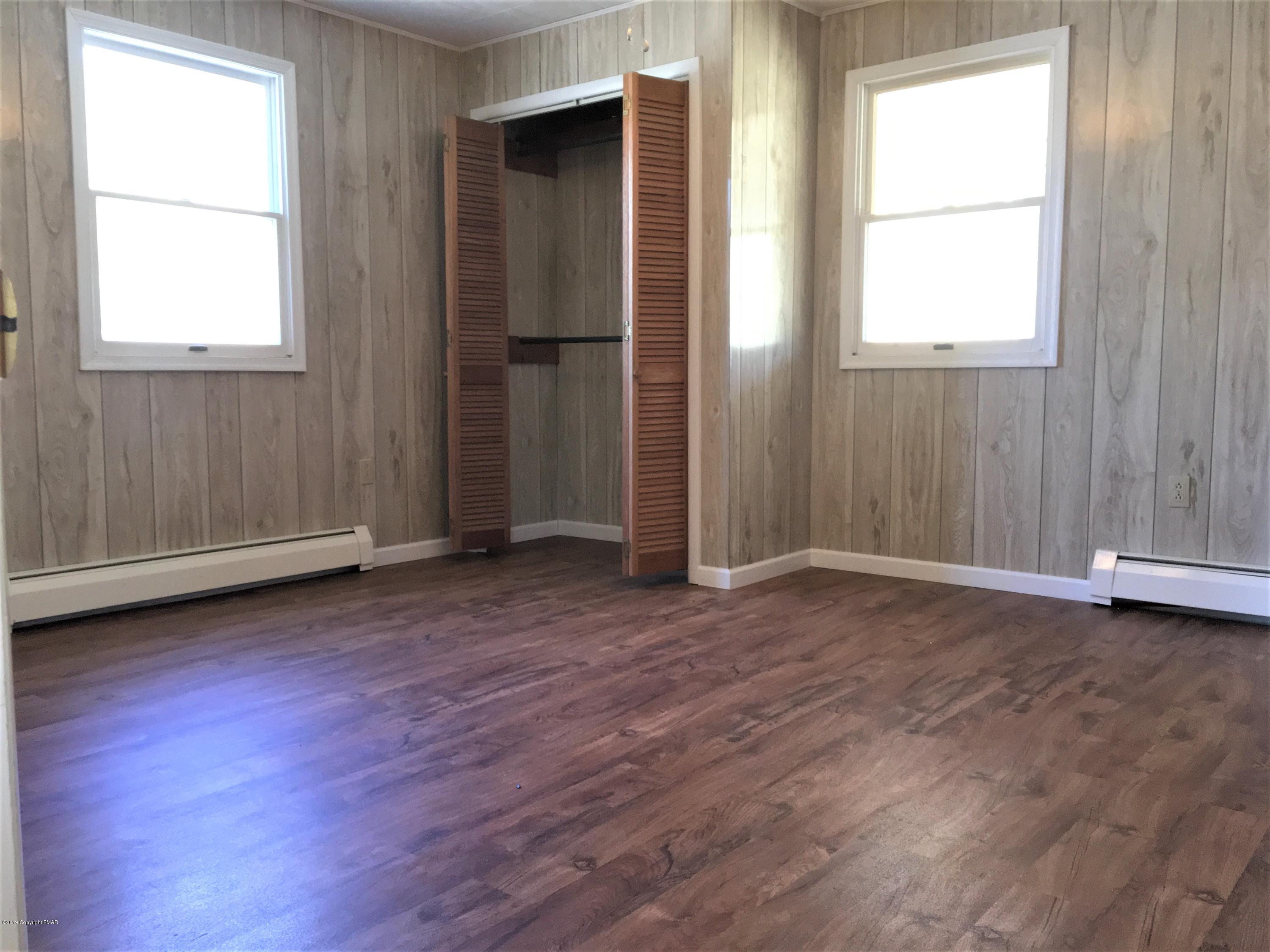 5736 Neola Road Stroudsburg, PA 18360 - Photo 19 of 37 an empty room with wooden floor and windows