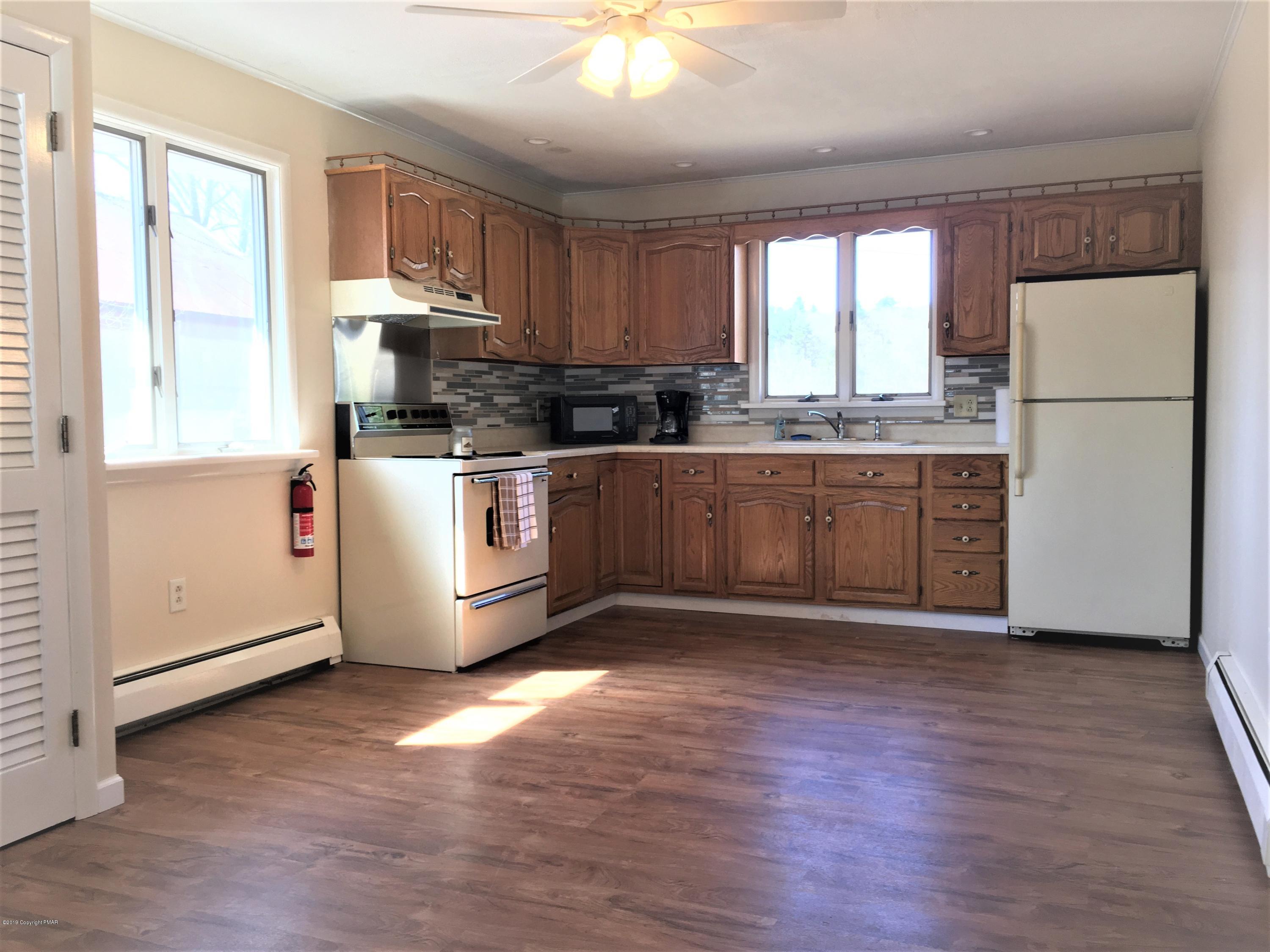 5736 Neola Road Stroudsburg, PA 18360 - Photo 6 of 37 a kitchen with stainless steel appliances granite countertop a stove a refrigerator a sink and a microwave