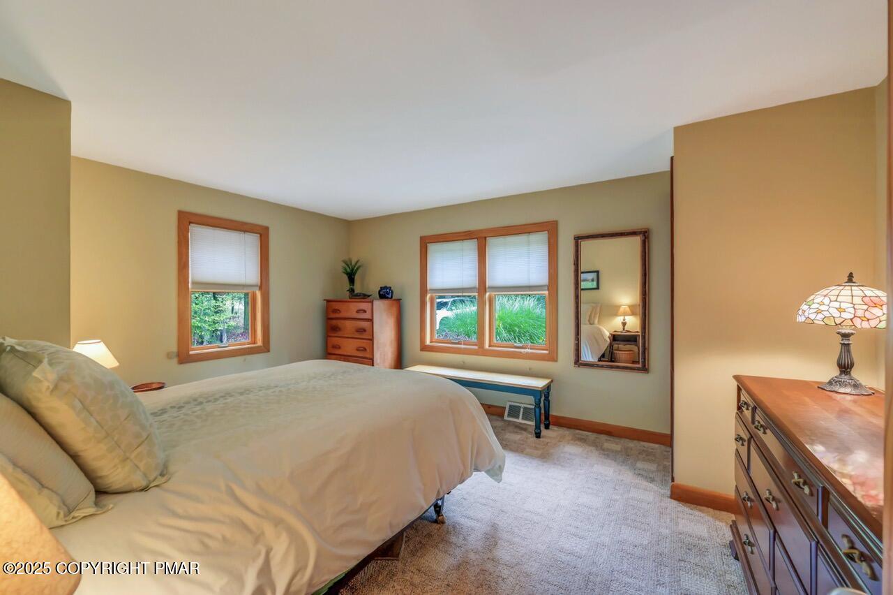 229 3rd Street Pocono Pines, PA 18350 - Photo 11 of 21 a spacious bedroom with a bed and a dresser next to a window