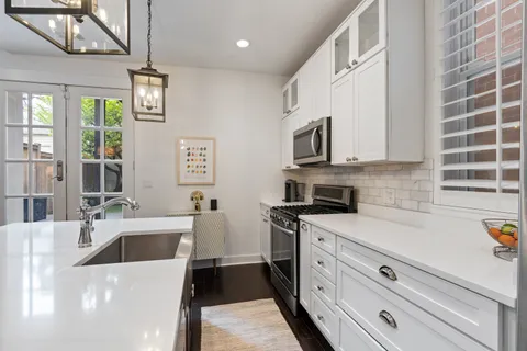 a kitchen with stainless steel appliances granite countertop a sink and a stove