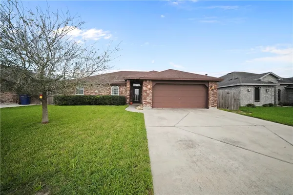 a front view of a house with yard and green space