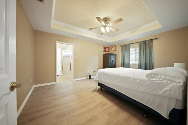 a spacious bedroom with a bed and a chandelier