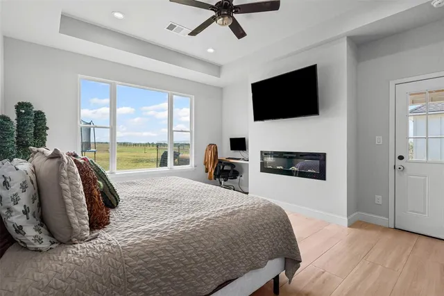 a spacious bedroom with a bed and a flat screen tv