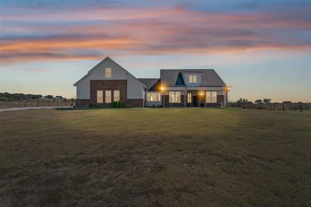a view of a house with a yard and lake view