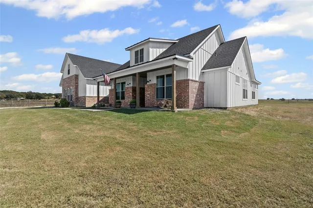 a view of a big house with a big yard and large trees