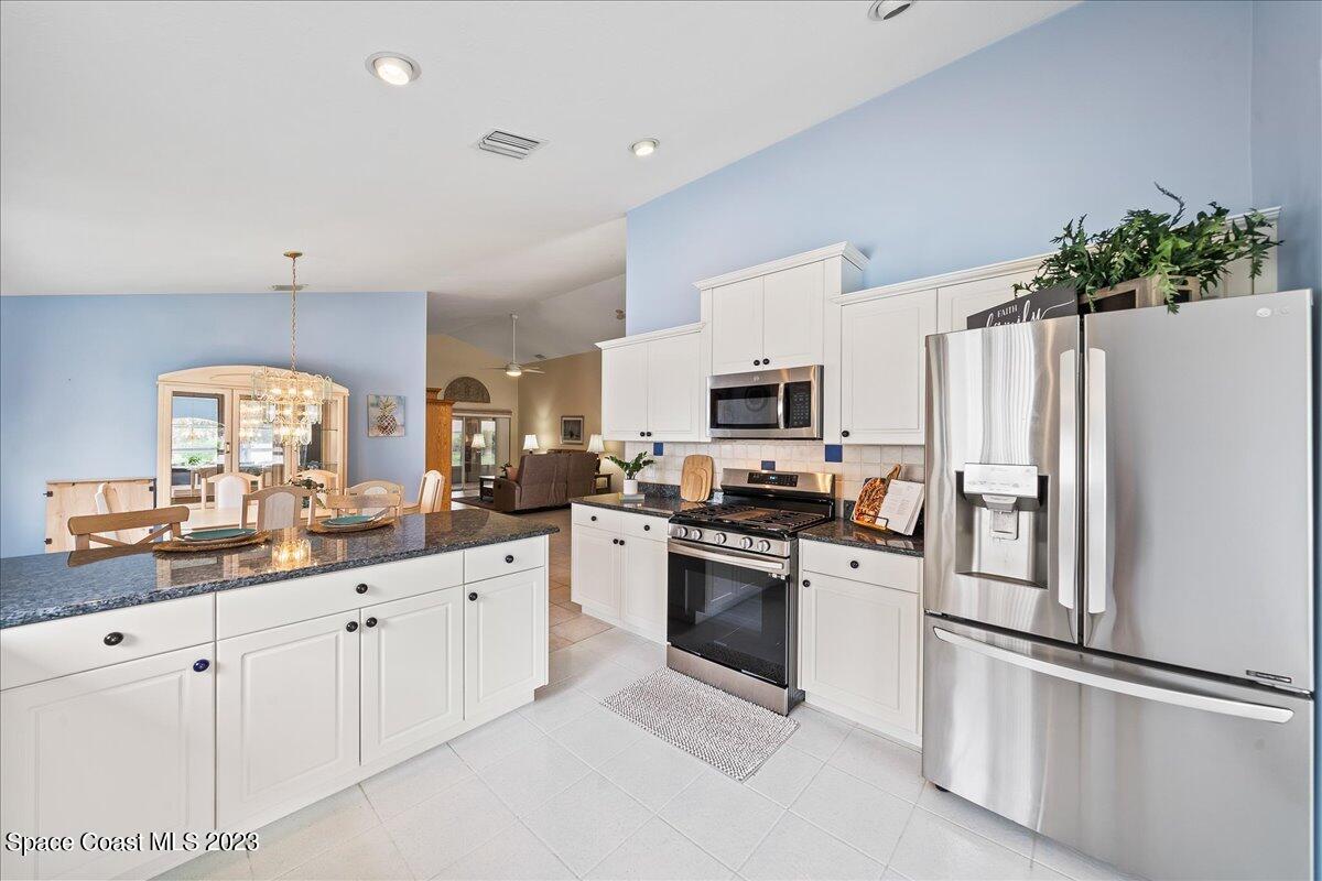 1643 Keys Gate Drive Melbourne, FL 32940 - Photo 12 of 43 a kitchen with white cabinets and stainless steel appliances