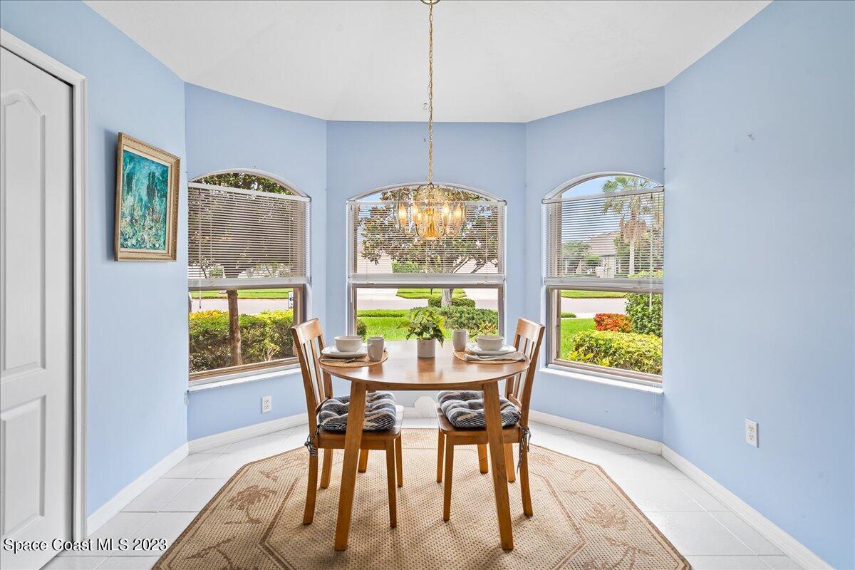 1643 Keys Gate Drive Melbourne, FL 32940 - Photo 14 of 43 a dining room with furniture a chandelier and wooden floor