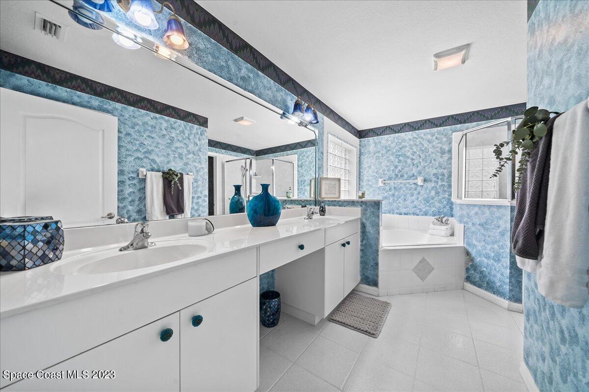 1643 Keys Gate Drive Melbourne, FL 32940 - Photo 19 of 43 a bathroom with a double vanity sink a toilet a mirror and bathtub