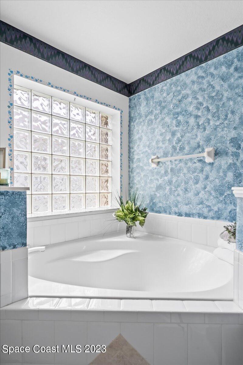 1643 Keys Gate Drive Melbourne, FL 32940 - Photo 20 of 43 a bathroom with a bathtub and next to a window