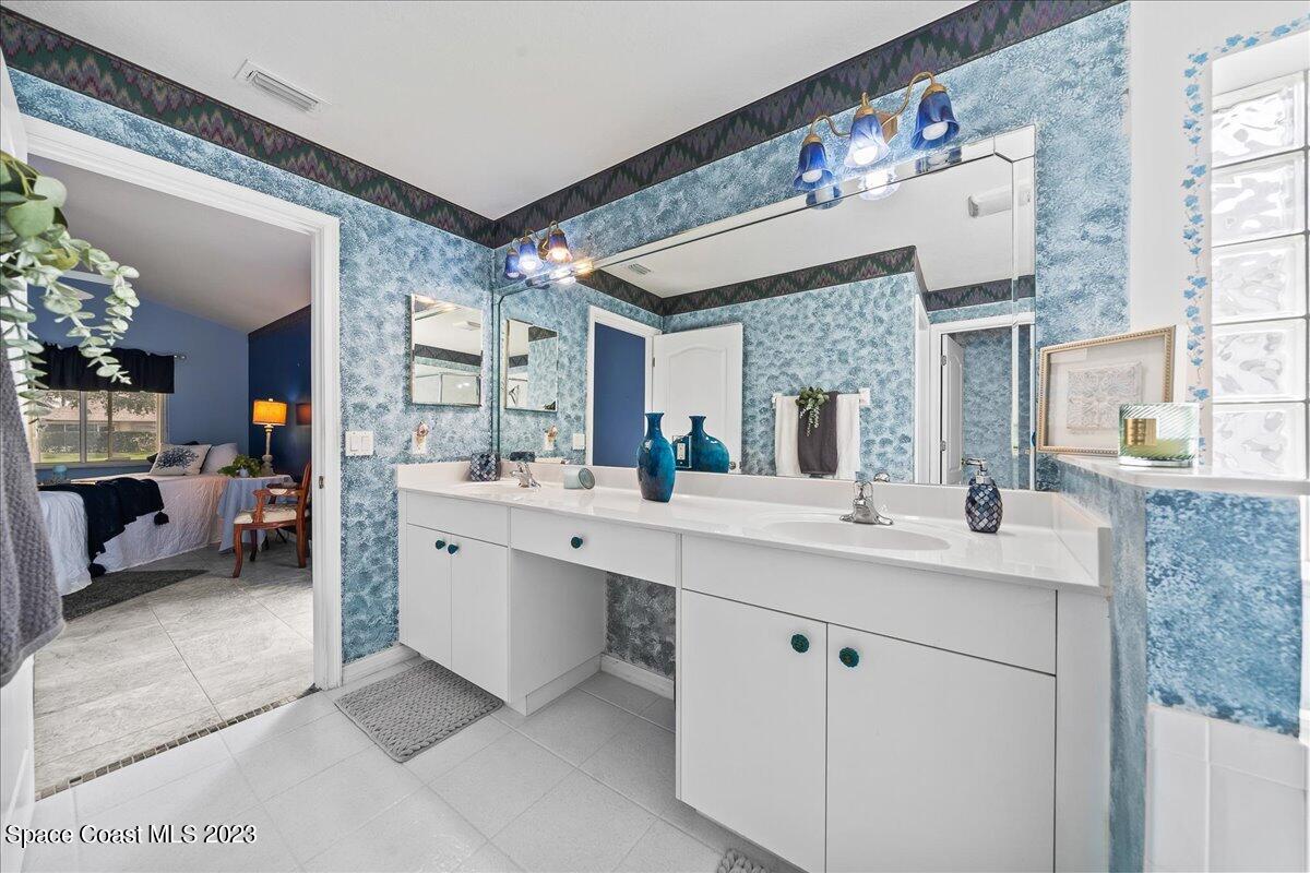 1643 Keys Gate Drive Melbourne, FL 32940 - Photo 22 of 43 a en suite bathroom with a double vanity sink mirror and