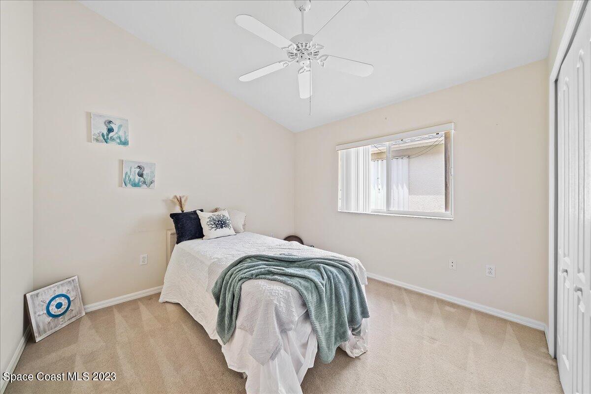 1643 Keys Gate Drive Melbourne, FL 32940 - Photo 23 of 43 a bedroom with a bed and a chandelier