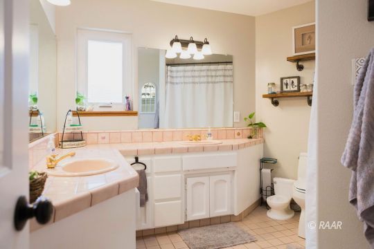 308 North Nolan Street Ridgecrest, CA 93555 - Photo 28 of 35 a bathroom with a sink vanity mirror and toilet