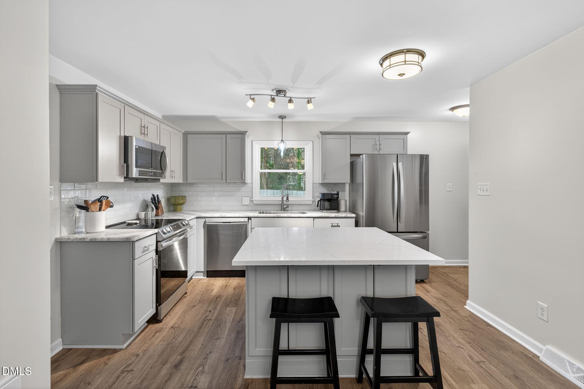 5620 Old Forge Circle Raleigh, NC 27609 - Photo 22 of 46 a kitchen with kitchen island a cabinets counter space and stainless steel appliances