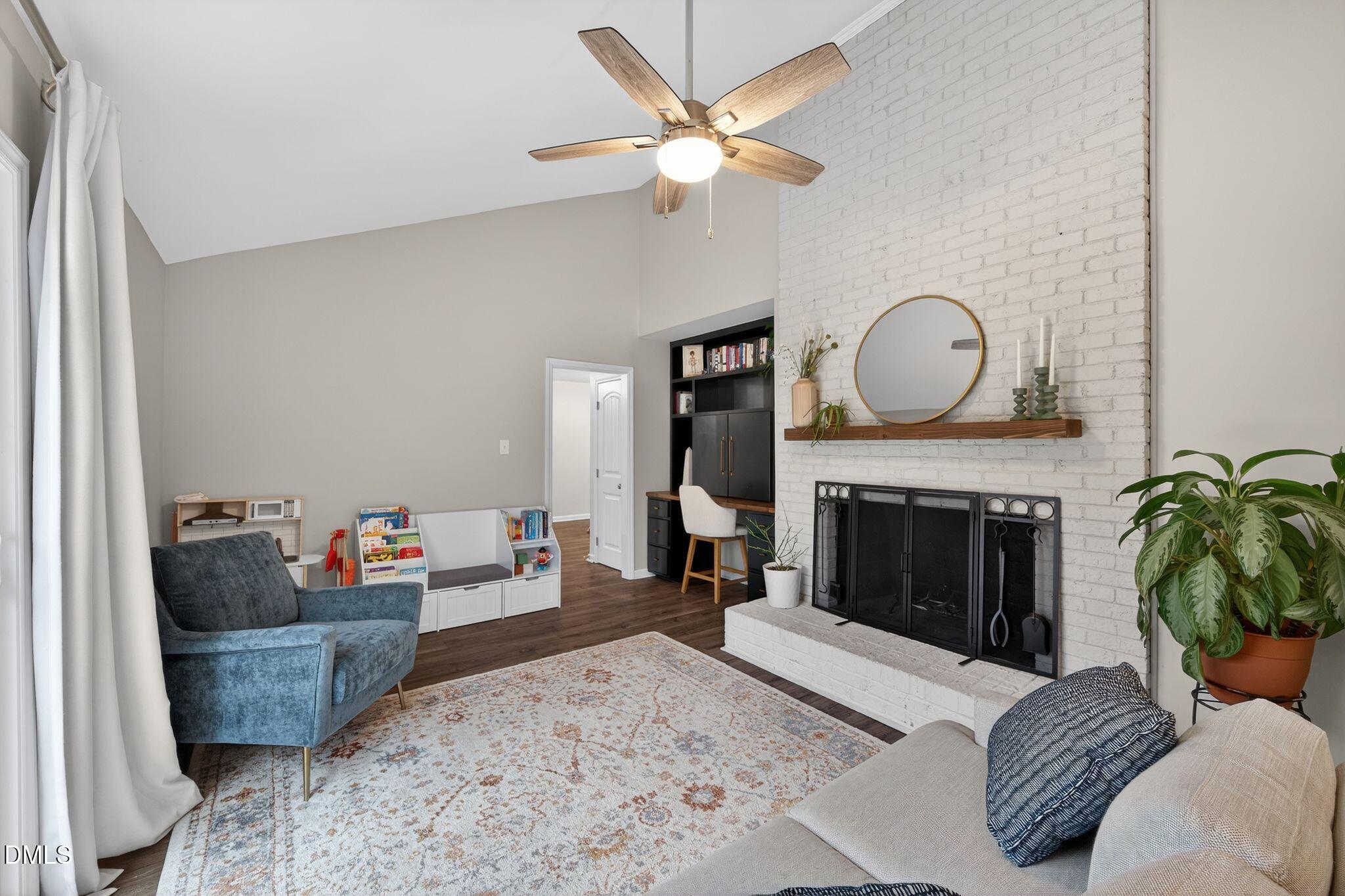 5620 Old Forge Circle Raleigh, NC 27609 - Photo 29 of 46 a living room with furniture a fireplace and a chandelier